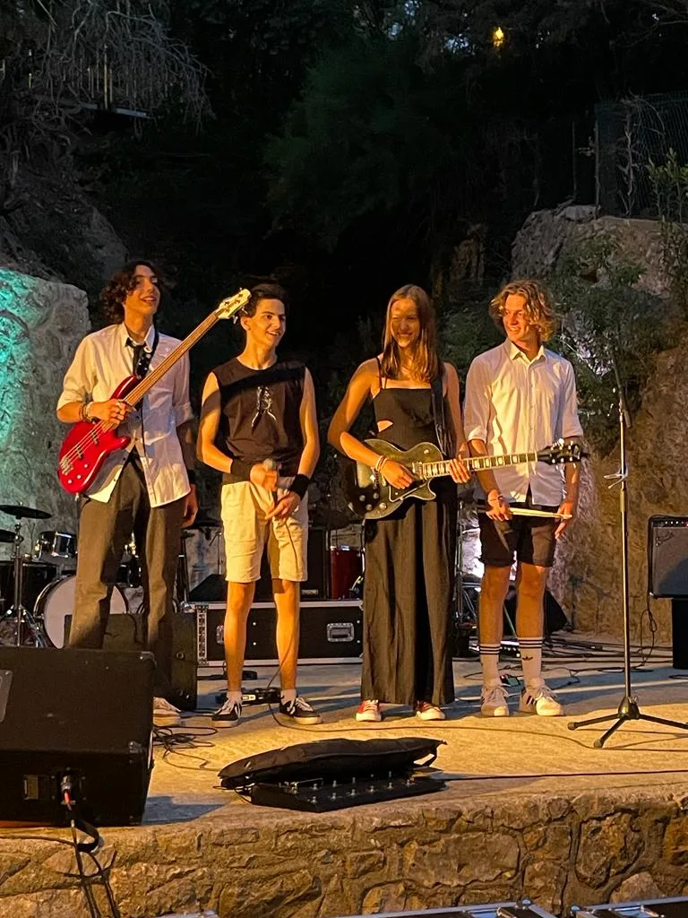 Les quatre membres de Kairos sur scène en plein air, de nuit, instruments en main